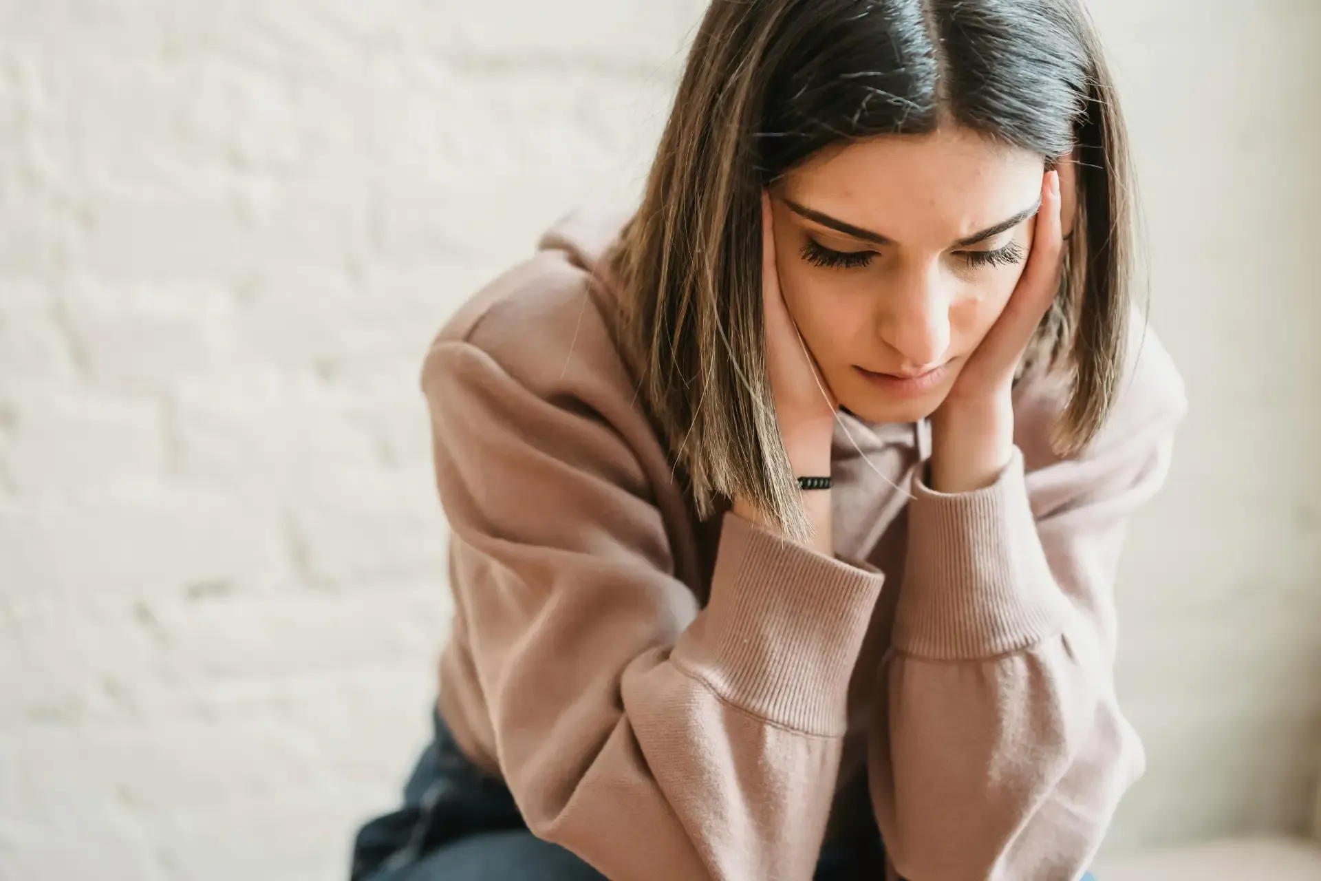 Woman sitting quietly with her head resting in her hands