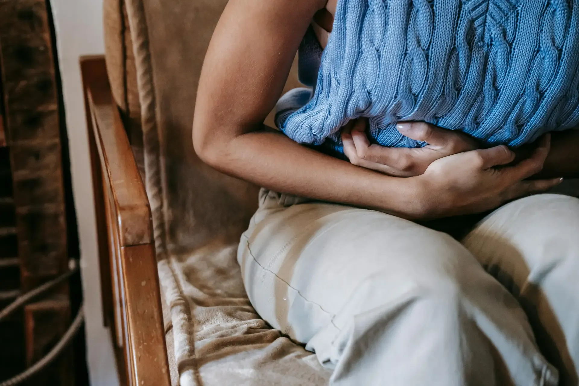 Person resting with a hot water bottle on their stomach