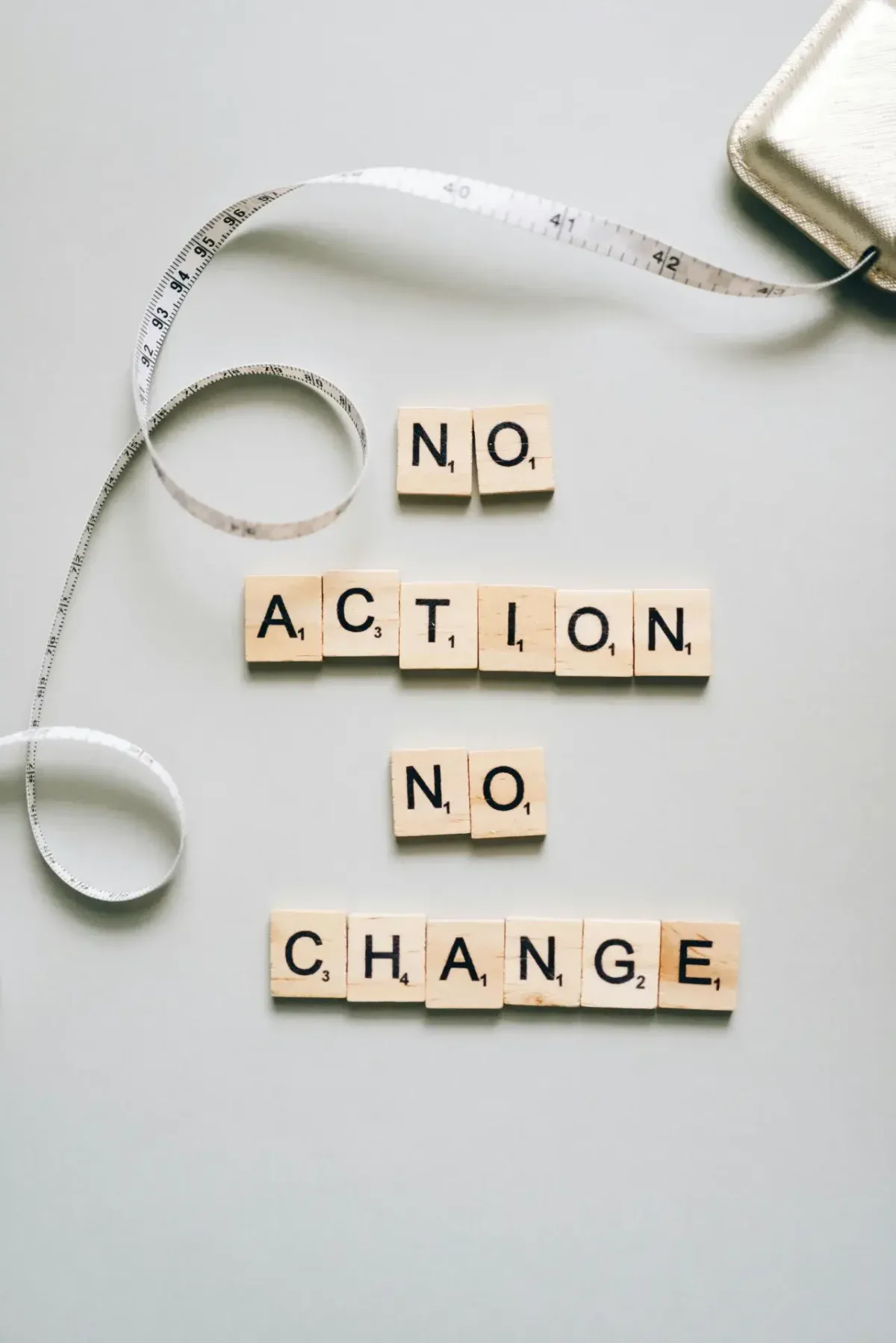 Scrabble tiles spelling No Action No Change