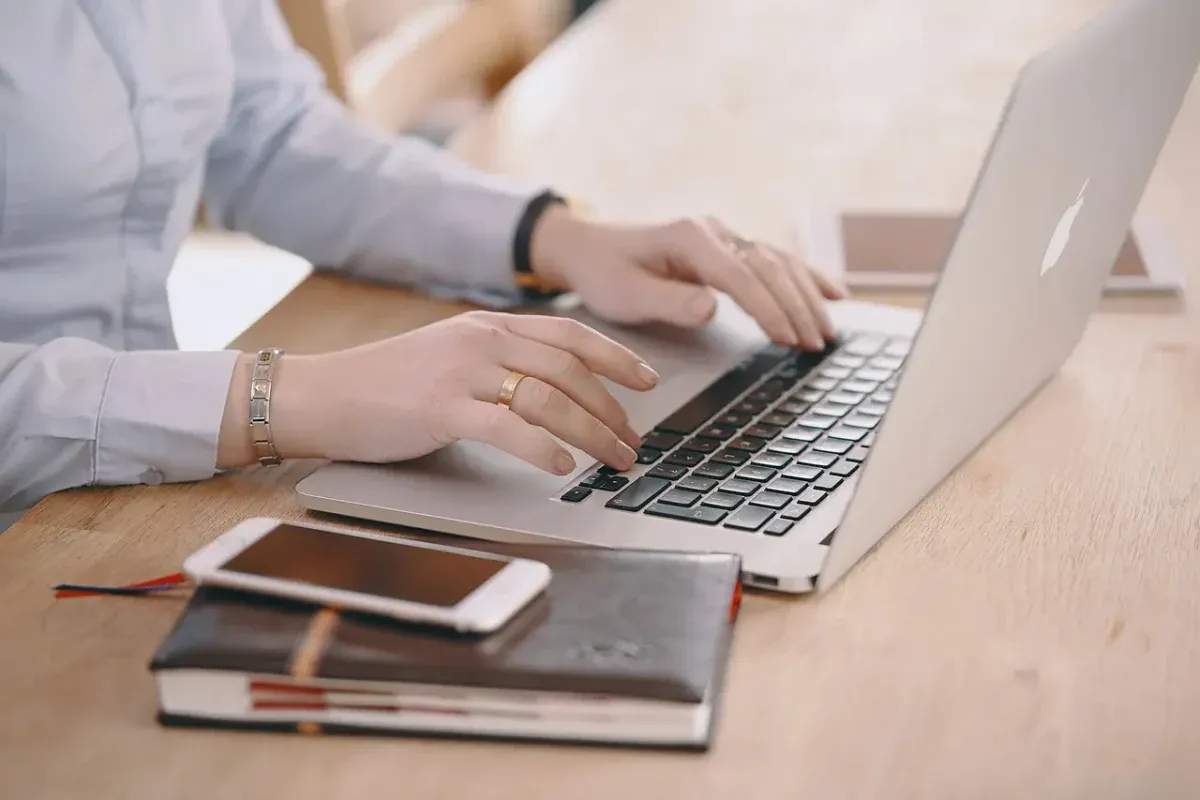 Hands typing on a laptop during an online consultation