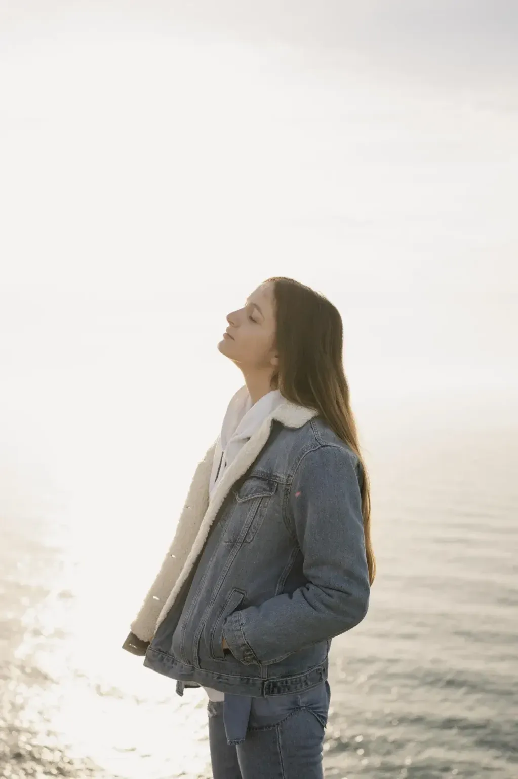 Woman standing peacefully by the ocean
