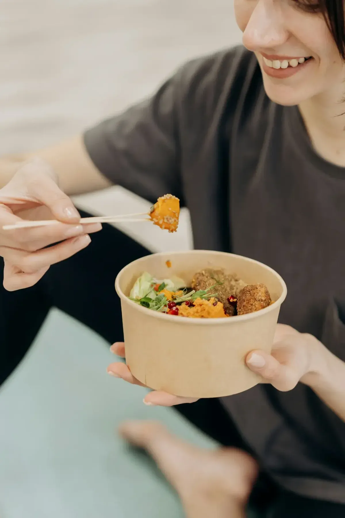 Woman smiling while eating a healthy meal