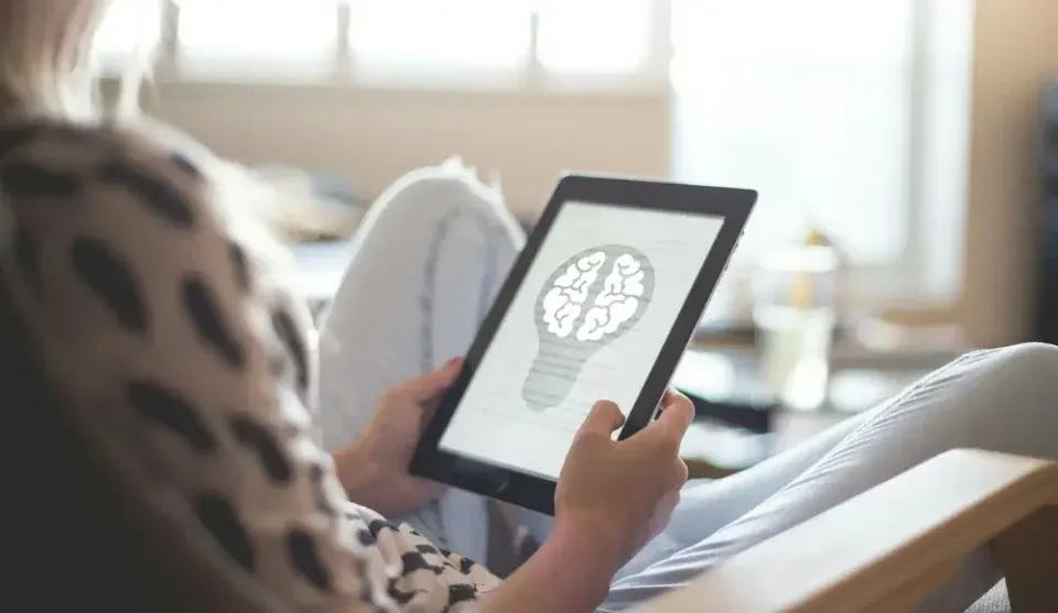 Person on a tablet showing a brain illustration