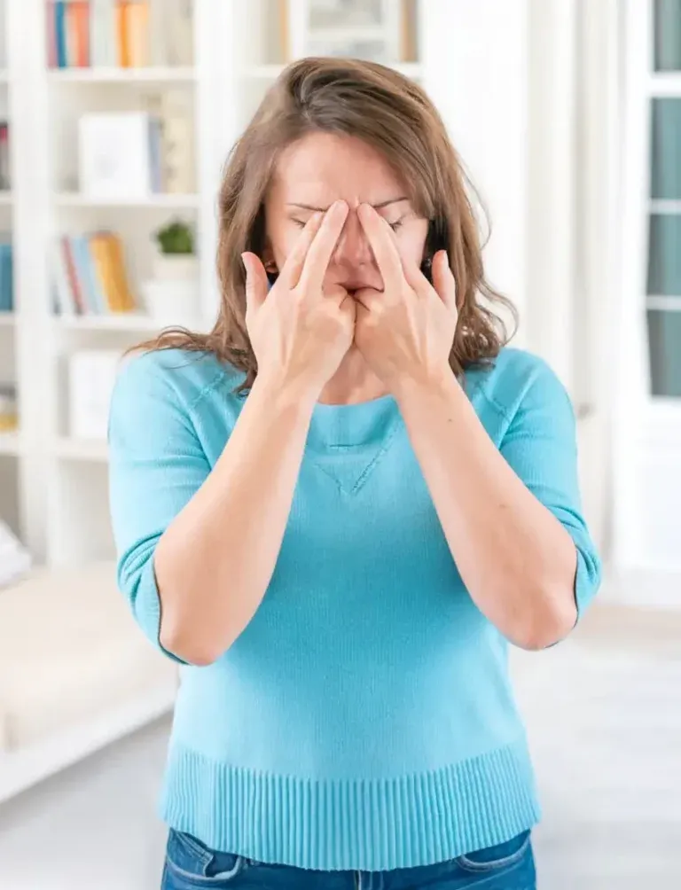 Woman with her hands gently resting over her face during a tapping session